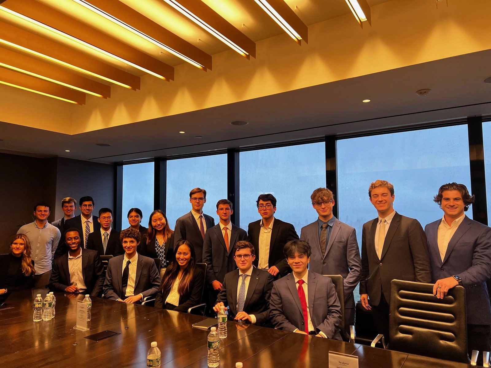The group around a long boardroom table during a firm visit.
