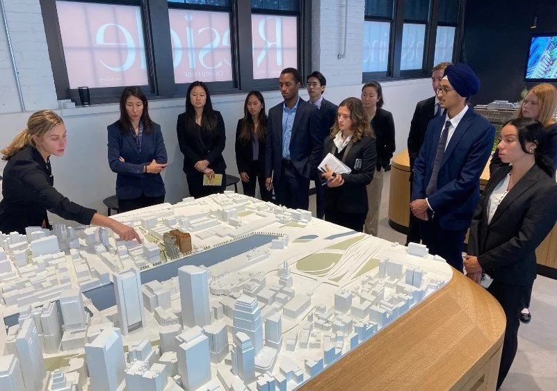An executive walking members through a scale model of a city district.