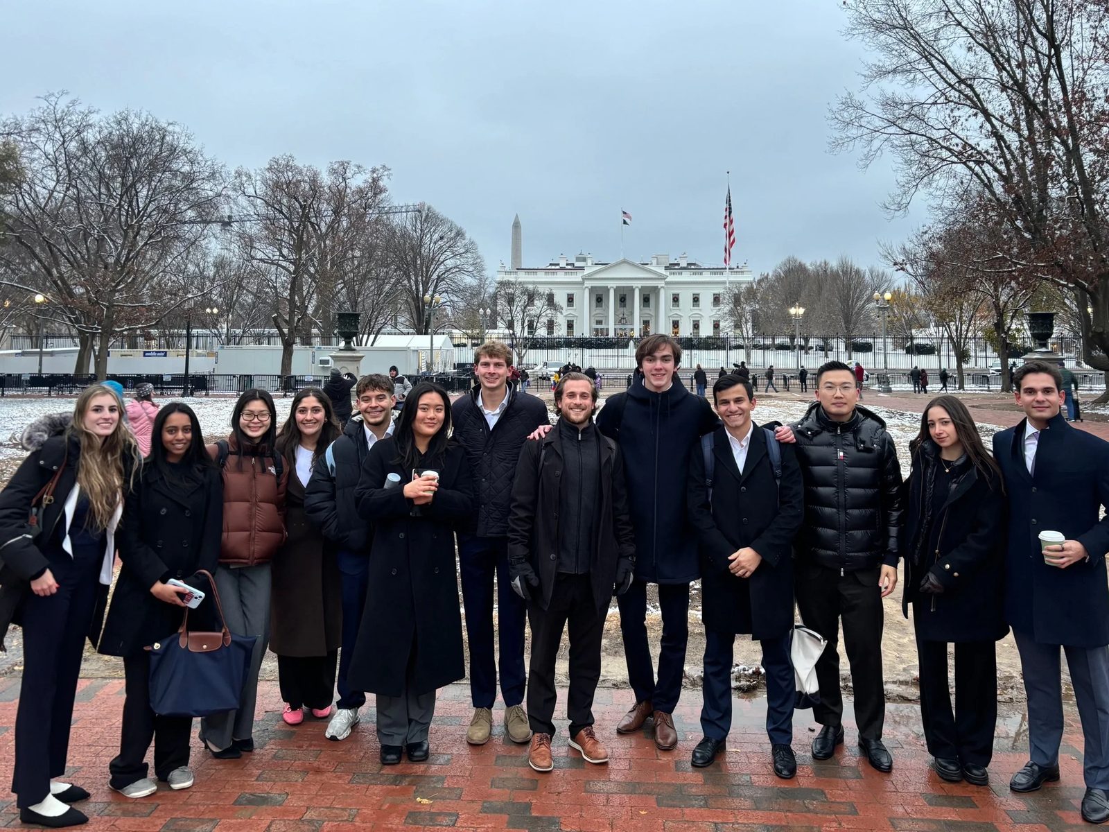 Members in winter coats in front of the White House during a Washington, D.C. trek.